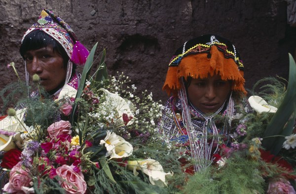 PERU Cusco Pisac Young couple in traditional dress behind flower display during village festival.Cuzco Pisaq American Cusco Peruvian Pisac South America Hispanic Latin America Latino Cuzco Pisaq American Cusco Peruvian Pisac South America Hispanic Latin America Latino