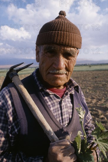 TURKEY  Antalya Portrait of farmer carrying hoe over his shoulder.EurasiaEuropean Middle East Turkish Turkiye Western Asia