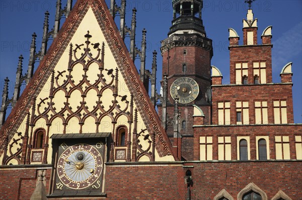 Poland, Wroclaw, Town Hall with decorative gable, red  brickwork, sundial with the clock tower of the Municipal Museum behind.
