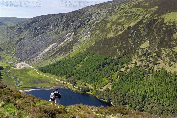 IRELAND, County Wicklow, Glendalough, A couple enjoy the view over the Upper Lake from the Spink Trail.