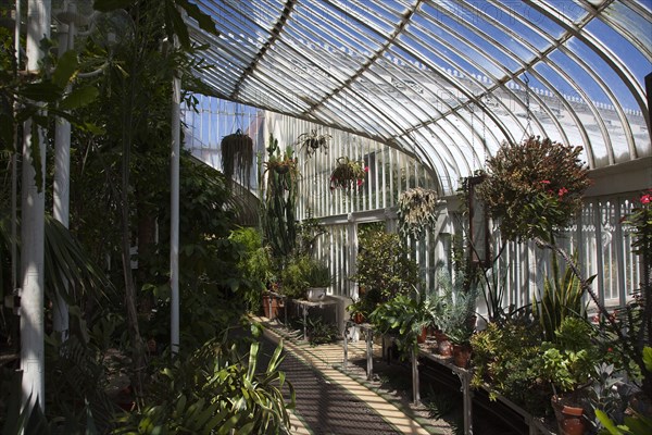 Ireland, Northern, Belfast, Botanic Gardens with people sat on benches outside the Palm House next to Queens University both designe by architect Charles Lanyon.