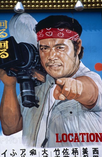 Japan, Honshu, Tokyo, Painted billboard film poster of Japanese man pointing whilst holding a camera with the English word Location on the poster.