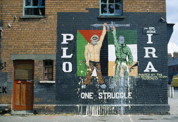 Ireland, North, Belfast, PLO IRA Irish Republican mural on the side of a terrace house on the corner with Falls Road.