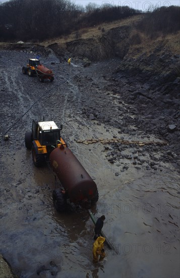 Wales, Dyfed, Stackpole Quay, Workers clearing beached oil from grounded tanker the Sea Empress in 1996.