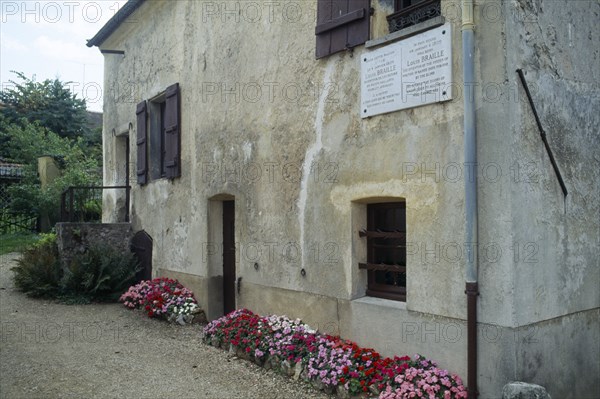 France, Ile de France, Coupvray, Marble commemorative plaque under a shuttered window on the wall of the house where Louis Braille lived in the commune.