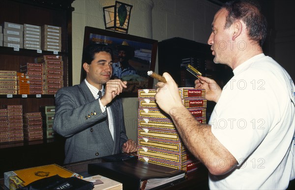 Cuba, Havana, Partagas Cigar factory shop. Man paying for purchases with credit card.