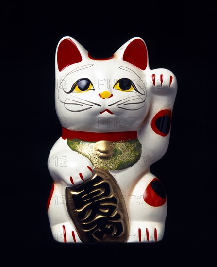 Japan, Honshu, Kyoto, Traditional statue of Maneki Neko Beckoning Cat associated with good luck and wealth also known as Welcoming Cat or Money Cat or Inviting Cat or Money cat or Fortune Cat or Lucky Cat often displayed in shops and stores and often used as piggy banks.