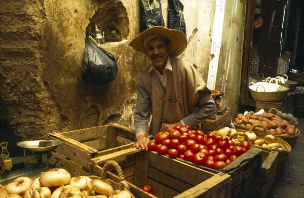 MOROCCO, Fez, Male stallholder behind crates of produce at the fruit market in the souk.