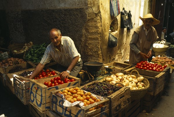 MOROCCO, Fez, Male stallholders behind crates of produce at the fruit market in the souk.