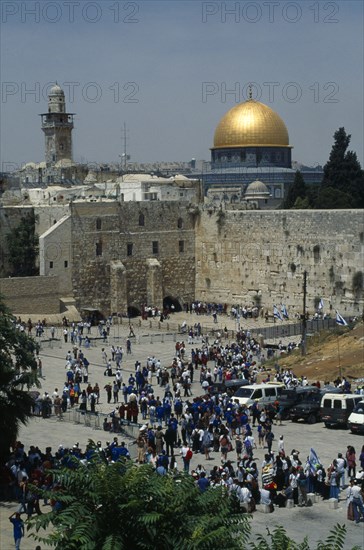 Israel, Jerusalem, Gold dome of the Aska Mosque and western or Wailing Wall with crowds of worshippers.