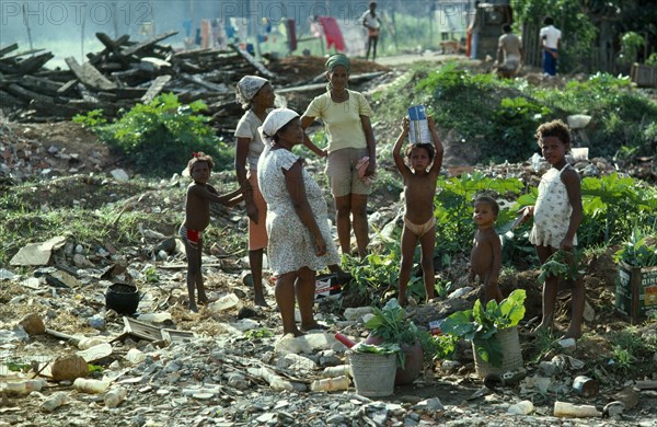 Brazil, Bahia, Salvador, Slum dwelling family foraging on rubbish dump for things to sell.