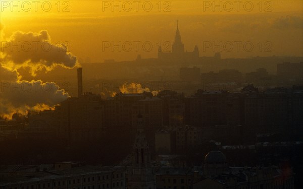 Russia, Moscow, Thick smoke from industrial chimneys hanging over the city at sunset.