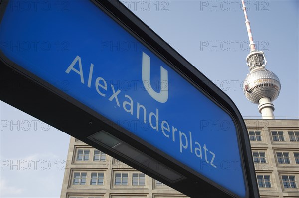 Germany, Berlin, Alexanderplatz, U Bahn sign for Alexanderplatz with Fernsehturm & office building in background.