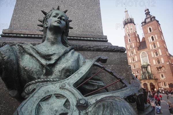 Poland, Krakow, Detail of female figure on monument to the polish romantic poet Adam Mickiewicz by Teodor Rygier in 1898 in the Rynek Glowny market square with Mariacki Basilica or Church of St Mary in the background.