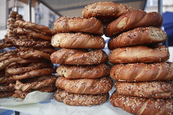 Poland, Krakow, Obwarzaneck, twisted rings of bread strewn with poppy sale for sale from street vendor's stall.