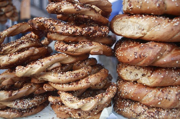 Poland, Krakow, Obwarzaneck,twisted rings of bread strewn with poppy sale for sale from street vendor's stall.