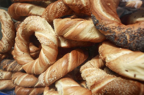 Poland, Krakow, Obwarzaneck, twisted rings of bread strewn with poppy sale, for sale from street vendor's stall.