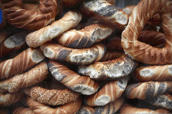 Poland, Krakow, Obwarzaneck, twisted rings of bread strewn with poppy sale for sale from street vendors stall.