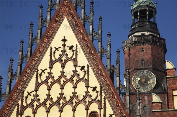 Poland, Wroclaw, part view of the decorative gable of the Town Hall with the clock tower of the Municipal Museum behind.