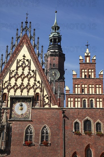 Poland, Wroclaw, Town Hall with sundial & decorative gable & the clock tower of the Municipal Museum in the background.