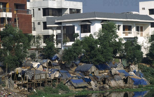 Bangladesh, Dhaka, Slum dwellings with expensive apartments behind.