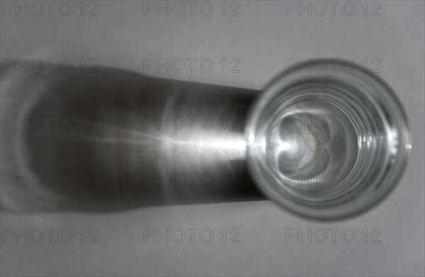 Science, Caustic Curve, Apex of curve shown on background with light passing through water in a glass.