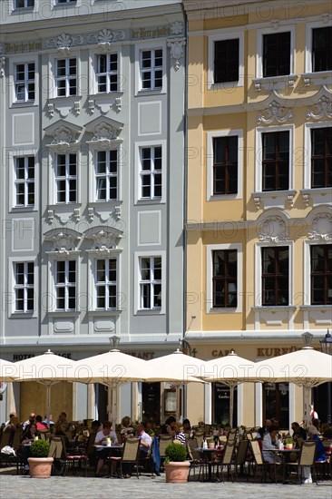 GERMANY, Saxony, Dresden, People sitting at restaurant cafe tables under umbrellas in Neumarkt beside restored buildings in the square.