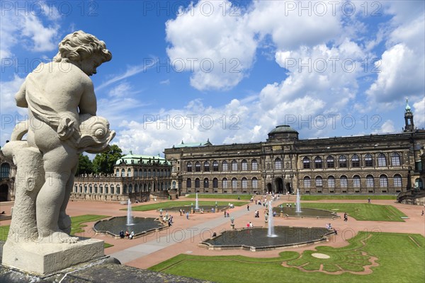 GERMANY, Saxony, Dresden, The central Courtyard and Picture Gallery of the restored Baroque Zwinger Palace gardens busy with tourists seen from the statue lined Rampart originally built between 1710 and 1732 after a design by Matthäus Daniel Pöppelmann in collaboration with sculptor Balthasar Permoser.