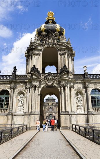 GERMANY, Saxony, Dresden, The Crown Gate or Kronentor of the restored Baroque Zwinger Palace with tourists walking through originally built between 1710 and 1732 after a design by Matthäus Daniel Pöppelmann in collaboration with sculptor Balthasar Permoser.