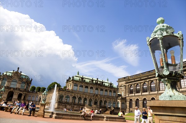 GERMANY, Saxony, Dresden, The central Courtyard of the restored Baroque Zwinger Palace gardens busy with tourists originally built between 1710 and 1732 after a design by Matthäus Daniel Pöppelmann in collaboration with sculptor Balthasar Permoser with the Rampart Pavilion on the left and the Picture gallery on the right.
