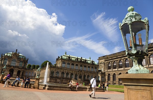 GERMANY, Saxony, Dresden, The central Courtyard of the restored Baroque Zwinger Palace gardens busy with tourists originally built between 1710 and 1732 after a design by Matthäus Daniel Pöppelmann in collaboration with sculptor Balthasar Permoser with the Rampart Pavilion on the left and the Picture gallery on the right.