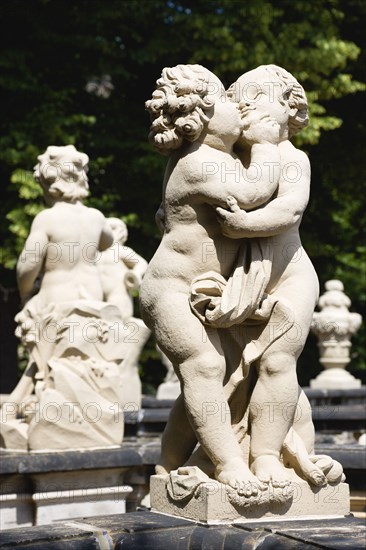 GERMANY, Saxony, Dresden, Statue of two kissing cherubs in the restored Baroque Zwinger Palace Gardens.