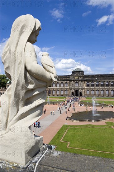 GERMANY, Saxony, Dresden, The central Courtyard and Picture Gallery of the restored Baroque Zwinger Palace gardens busy with tourists seen from the statue lined Rampart originally built between 1710 and 1732 after a design by Matthäus Daniel Pöppelmann in collaboration with sculptor Balthasar Permoser.