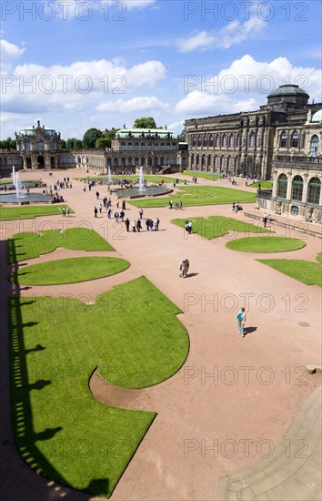 GERMANY, Saxony, Dresden, The central Courtyard of the restored Baroque Zwinger Palace gardens busy with tourists originally built between 1710 and 1732 after a design by Matthäus Daniel Pöppelmann in collaboration with sculptor Balthasar Permoser with the Rampart Pavilion on the left and the Picture Gallery on the right.