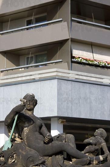 GERMANY, Saxony, Dresden, Statue of a naked reclining woman and a laughing cherub in front of an apartment building in Neustädter market square.