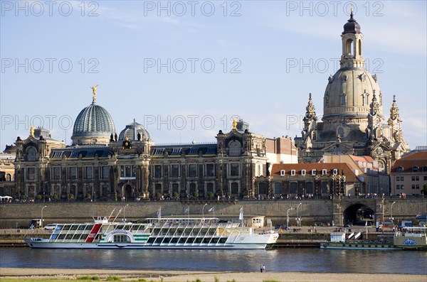 GERMANY, Saxony, Dresden, The city skyline with cruise boats moored on the River Elbe in front of the embankment buildings on the Bruhl Terrace busy with tourists of the Art Academy and the restored Baroque Frauenkirche Church of Our Lady Dome.