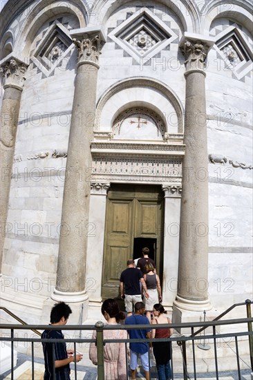 ITALY, Tuscany, Pisa, The Campo dei Miracoli or Field of Miracles with a tour party of tourists at the entrance to the Leaning Tower or Torre Pendente belltower.