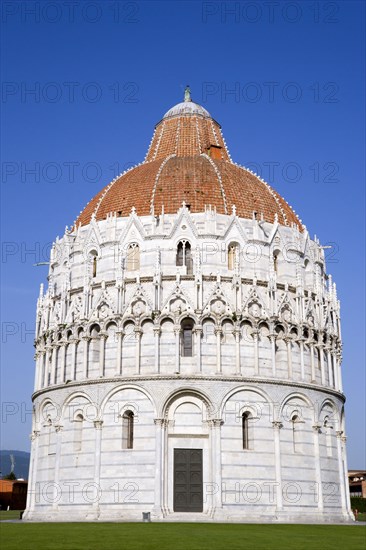ITALY, Tuscany, Pisa, Campo dei Miracoli or Field of Miracles with the Baptistry under a blue sky.
