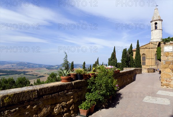 ITALY, Tuscany, Pienza, Val D'Orcia The belltower of the Duomo built in 1459 by the architect Rossellino for Pope Pius II seen from the Via Dell' Amore with cypress trees overlooking the countryside below.