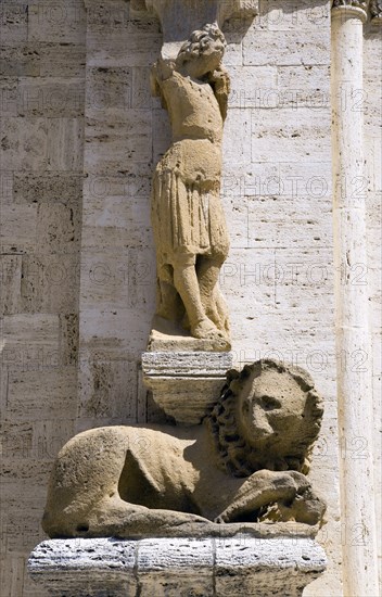 ITALY, Tuscany, San Quirico D'Orcia, One of the caryatid or zoomorphic columns of the portale di mezzogiorno or southern door of the Collegiata the Church of the saints Quirico and Giulitta attributed to the school of Giovanni Pisano showing a man and a lion.