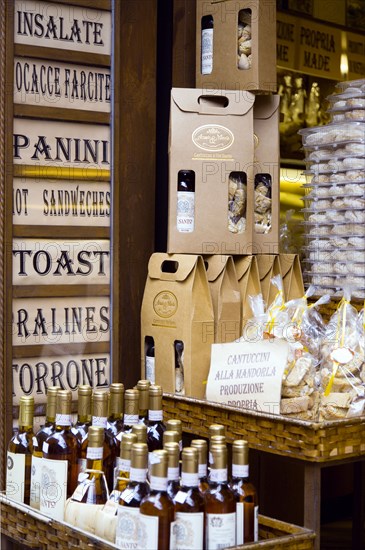 ITALY, Tuscan, San Gimignano, Shop display of chianti wines and cakes.