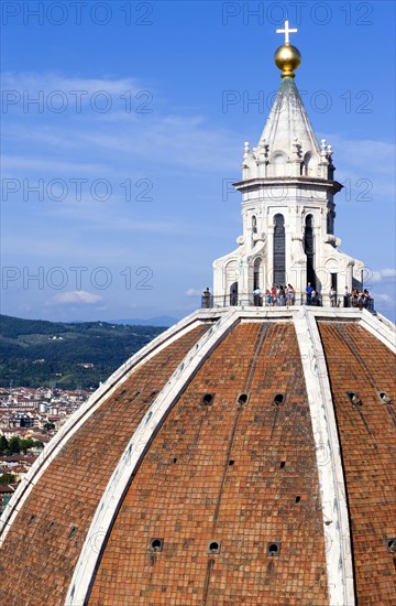 ITALY, Tuscany, Florence, The Dome of the Cathedral of Santa Maria del Fiore the Duomo by Brunelleschi with tourists on the viewing platform looking over the city towards the surrounding hills.