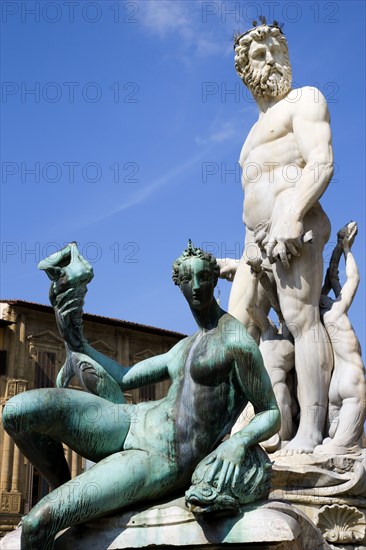ITALY, Tuscany, Florence, The 1575 Mannerist Neptune fountain with the Roman sea God surrounded by water nymphs commemorating Tuscan naval victories by Ammannatti in the Piazza della Signoria beside the Palazzo Vecchio.