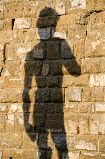 ITALY, Tuscany, Florence, Shadow of the replica Rennaisance statue of David by Michelangelo on the wall of the Palazzo Vecchio in the Piazza della Signoria.