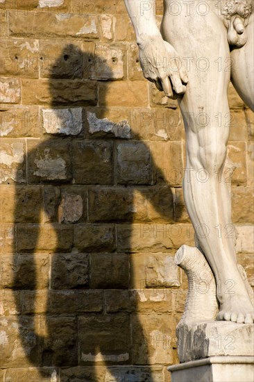 ITALY, Tuscany, Florence, Shadow of the replica Rennaisance statue of David by Michelangelo on the wall of the Palazzo Vecchio in the Piazza della Signoria.