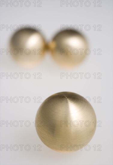 Industry, Machinery, Components, Three brass metal lathe turned ball bearings on a white background