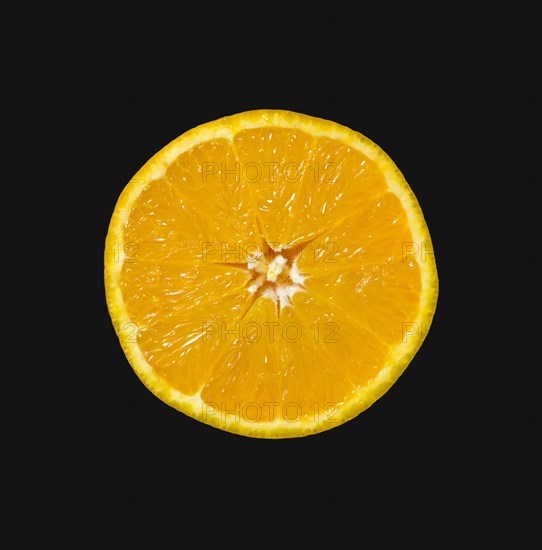 Food, Fruit, Oranges, One single ripe orange cut in half showing core and segments against a black background.