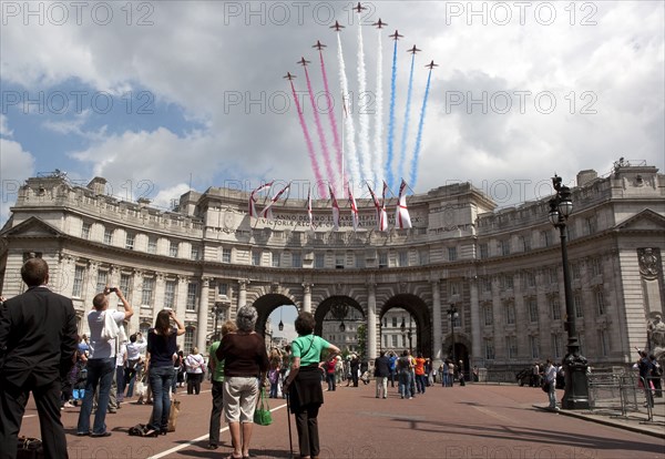 ENGLAND, London, The Mall and Horseguards, Admiralty Arch, People are looking at flying military aircrafts on formation which are leaving colored line trails behind them, as part of Queen of Englandís Elisabeth birthdays celebration.
