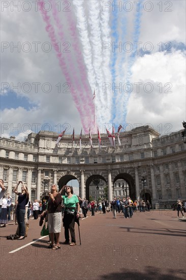 ENGLAND, London, The Mall and Horseguards, Admiralty Arch, People are looking at the colored line trails that were left from flying military aircrafts on formation, as part of Queen of Englandís Elisabeth birthdayís celebration.