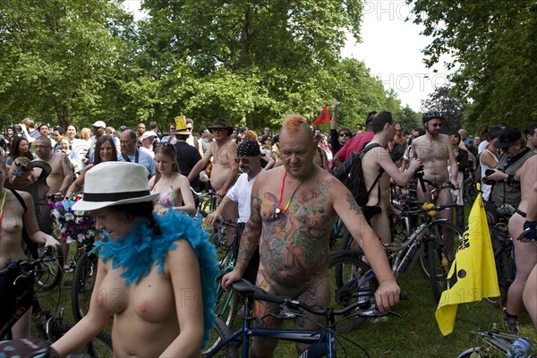 ENGLAND, London, Hyde Park, people with their bicycles, gathered together under the shade of the trees, waiting for the world naked bike ride protest parade to  
start.